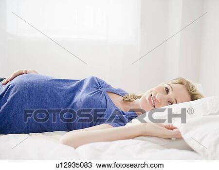Pregnant woman lying in bed View Large Photo Image Stock Image - Pregnant woman lying in bed. Fotosearch