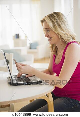 Stock Photo - Pregnant woman online shopping. Fotosearch