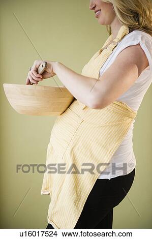 Pregnant woman preparing food View Large Photo Image Picture - Pregnant woman preparing food. Fotosearch