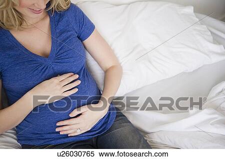 Pregnant woman sitting in bed View Large Photo Image Stock Photography - Pregnant woman sitting in bed. Fotosearch