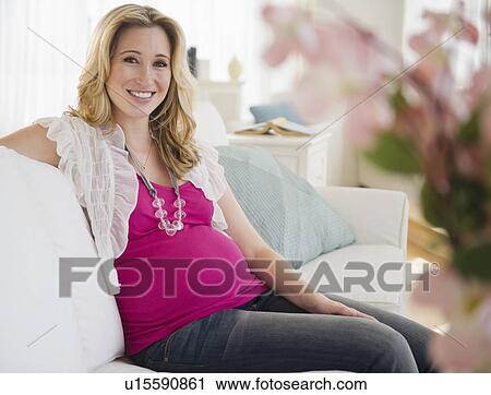 Pregnant woman sitting on sofa View Large Photo Image Stock Image - Pregnant woman sitting on sofa. Fotosearch