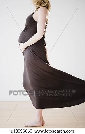 Pregnant woman touching belly View Large Photo Image Stock Photograph - Pregnant woman touching belly. Fotosearch
