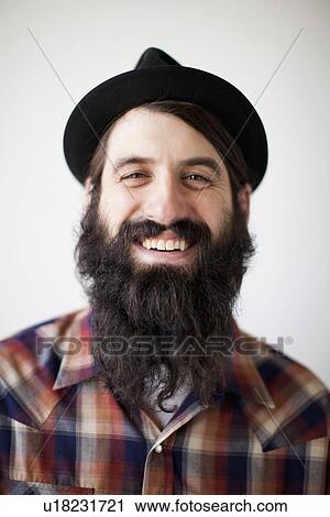 Stock Image - Profile of male character wearing long beard, hat and lumberjack shirt. Fotosearch