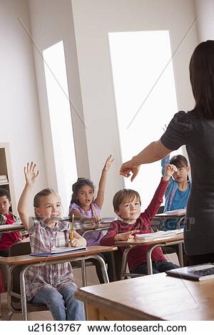 Pupils in classroom raising hands View Large Photo Image Stock Photo - Pupils in classroom raising hands. Fotosearch