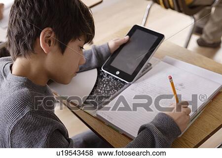 Schoolboy (12-13) with digital tablet at school View Large Photo Image Stock Photo - Schoolboy (12-13) with digital tablet at school. Fotosearch