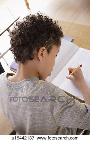 Schoolboy focused on writing in classroom View Large Photo Image Stock Photo - Schoolboy focused on writing in classroom. Fotosearch