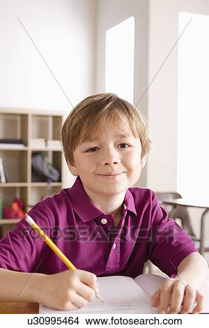 Picture - Schoolboy writing in notebook. Fotosearch