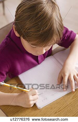 Schoolboy writing in notebook View Large Photo Image Stock Photograph - Schoolboy writing in notebook. Fotosearch