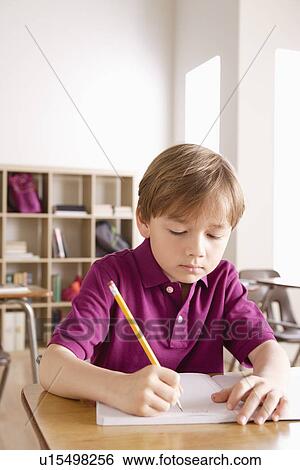 Schoolboy writing in notebook View Large Photo Image Stock Photograph - Schoolboy writing in notebook. Fotosearch