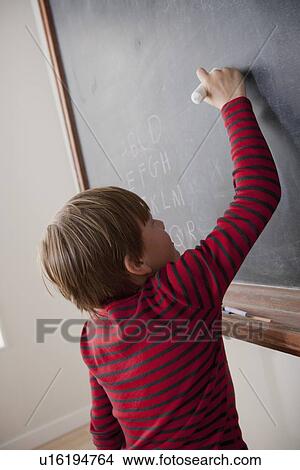 Schoolboy writing on blackboard View Large Photo Image Picture - Schoolboy writing on blackboard. Fotosearch