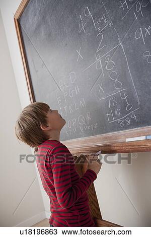 Schoolboy writing on blackboard View Large Photo Image Stock Image - Schoolboy writing on blackboard. Fotosearch