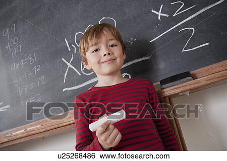 Schoolboy writing on blackboard View Large Photo Image Stock Photograph - Schoolboy writing on blackboard. Fotosearch
