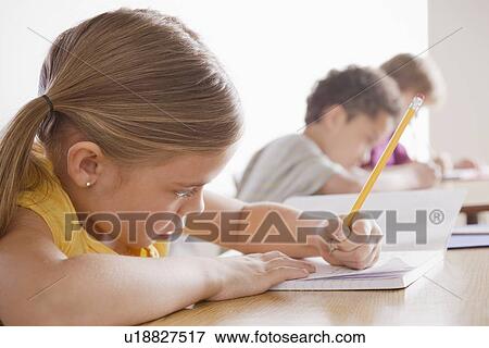 Schoolchildren focused on writing in classroom View Large Photo Image Stock Photo - Schoolchildren focused on writing in classroom. Fotosearch