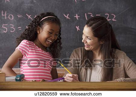 Schoolgirl (10-11) and teacher with blackboard in background View Large Photo Image Stock Photo - Schoolgirl (10-11) and teacher with blackboard in background. Fotosearch