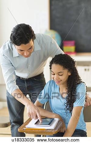 Schoolgirl (12-13) using tablet pc, assisted by teacher View Large Photo Image Stock Photography - Schoolgirl (12-13) using tablet pc, assisted by teacher. Fotosearch