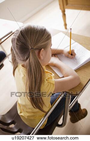 Schoolgirl focused on writing in classroom View Large Photo Image Stock Photo - Schoolgirl focused on writing in classroom. Fotosearch