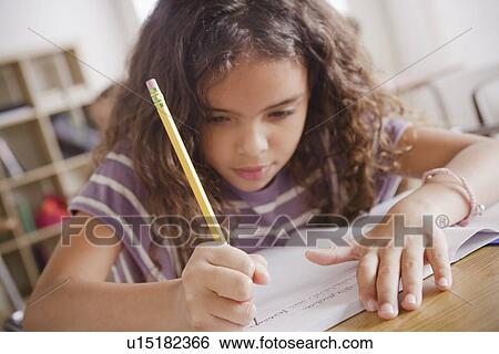 Schoolgirl focused on writing in classroom View Large Photo Image Stock Photograph - Schoolgirl focused on writing in classroom. Fotosearch