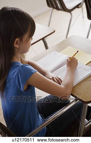 Schoolgirl focused on writing View Large Photo Image Stock Image - Schoolgirl focused on writing. Fotosearch