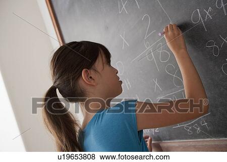 Stock Photo - Schoolgirl writing on blackboard. Fotosearch