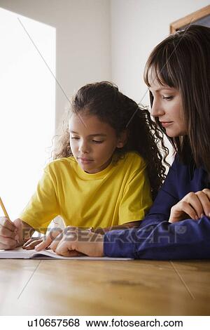 Schoolgirl writing with teacher in classroom View Large Photo Image Stock Photo - Schoolgirl writing with teacher in classroom. Fotosearch