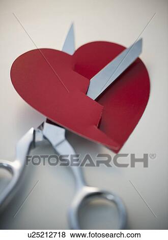 Stock Photo - Scissors cutting paper heart. Fotosearch