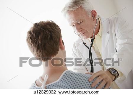Stock Image - Senior doctor examining patient. Fotosearch