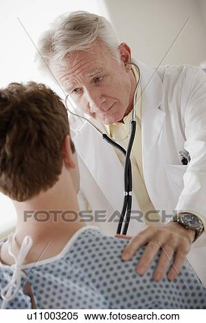 Senior doctor examining patient View Large Photo Image Stock Photography - Senior doctor examining patient. Fotosearch