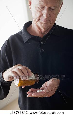 Stock Image - Senior man taking pills. Fotosearch