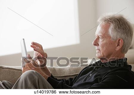Stock Photograph - Senior man using digital tablet. Fotosearch