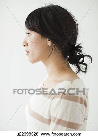 Side view of young woman, studio shot View Large Photo Image Stock Photo - Side view of young woman, studio shot. Fotosearch
