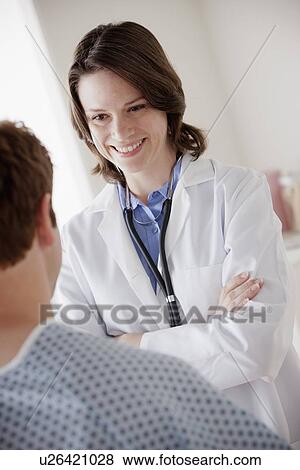 Stock Photo - Smiling doctor talking with patient. Fotosearch