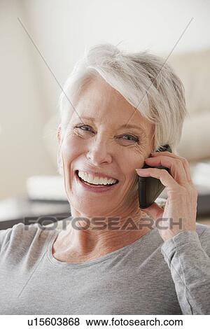 Smiling senior woman using mobile phone View Large Photo Image Stock Photo - Smiling senior woman using mobile phone. Fotosearch