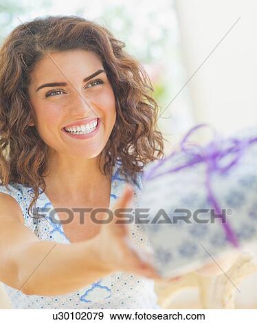 Smiling woman giving present View Large Photo Image Stock Photo - Smiling woman giving present. Fotosearch