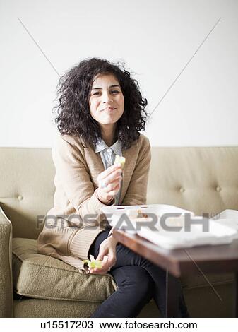 Stock Image - Smiling young woman having take away food. Fotosearch