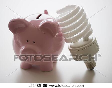 Stock Photo - Still life with piggy bank and energy efficient light bulb. Fotosearch