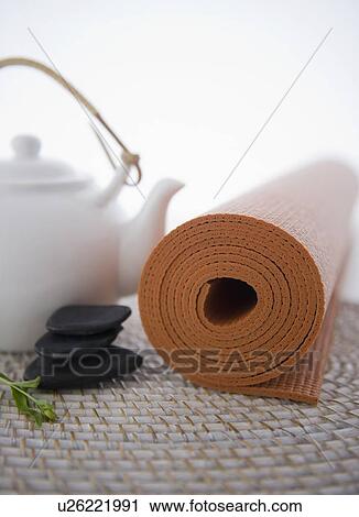 Stock Image - Still life with teapot, stones and yoga mat. Fotosearch