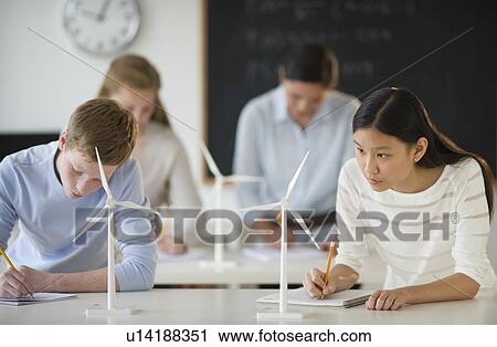 Stock Image - Students (14-19) examining wind turbines. Fotosearch