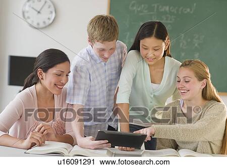 Stock Image - Students (14-19) using tablet pc in classroom. Fotosearch