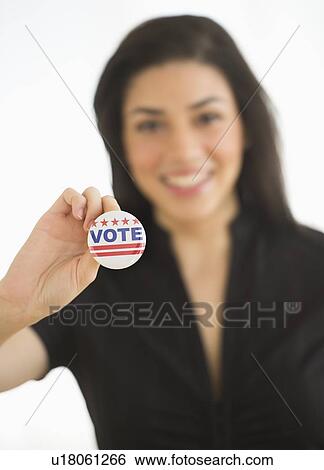 Studio portrait of young woman holding election badge View Large Photo Image Stock Photograph - Studio portrait of young woman holding election badge. Fotosearch