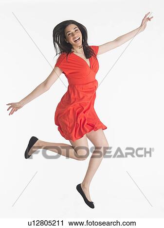 Studio portrait of young woman jumping View Large Photo Image Stock Image - Studio portrait of young woman jumping. Fotosearch