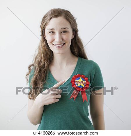 Studio shot of happy young woman showing winner badge View Large Photo Image Stock Photography - Studio shot of happy young woman showing winner badge. Fotosearch