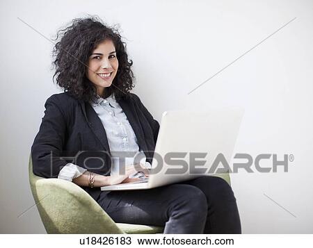 Studio shot of young woman using laptop View Large Photo Image Stock Image - Studio shot of young woman using laptop. Fotosearch