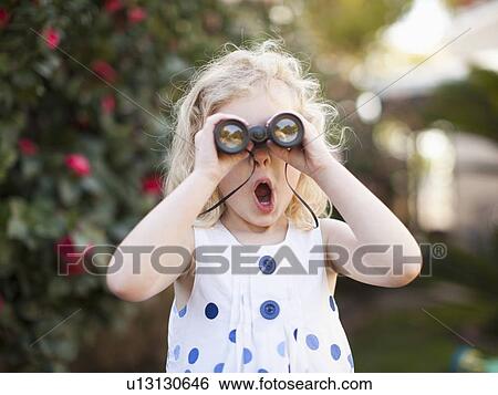 Stock Photograph - Surprised young girl (4-5) looking through binoculars. Fotosearch