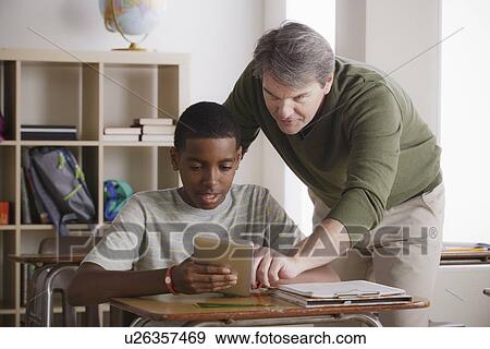 Stock Photo - Teacher and schoolboy (14-15). Fotosearch