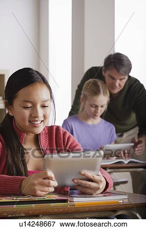 Stock Photo - Teacher and teenage students (14-15). Fotosearch