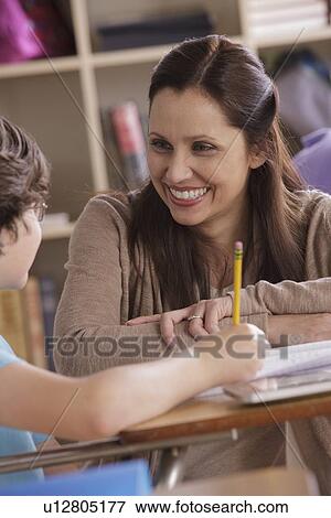 Teacher assisting schoolboy (10-11) View Large Photo Image Stock Photo - Teacher assisting schoolboy (10-11). Fotosearch