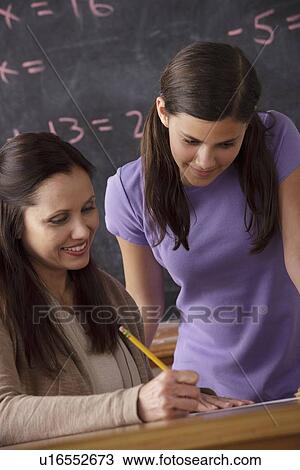 Teacher explaining exercise to schoolgirl (12-13) with blackboard in background View Large Photo Image Stock Image - Teacher explaining exercise to schoolgirl (12-13) with blackboard in background. Fotosearch