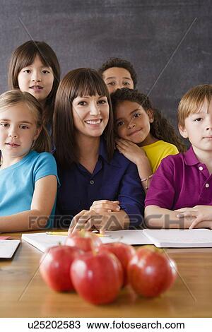 Teacher with group of pupils and apples on desk View Large Photo Image Stock Image - Teacher with group of pupils and apples on desk. Fotosearch