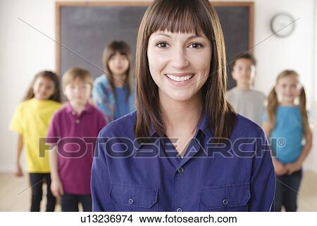 Teacher with group of pupils in front of blackboard View Large Photo Image Picture - Teacher with group of pupils in front of blackboard. Fotosearch