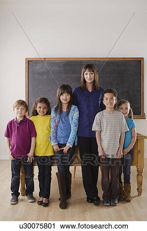 Teacher with group of pupils in front of blackboard View Large Photo Image Stock Image - Teacher with group of pupils in front of blackboard. Fotosearch